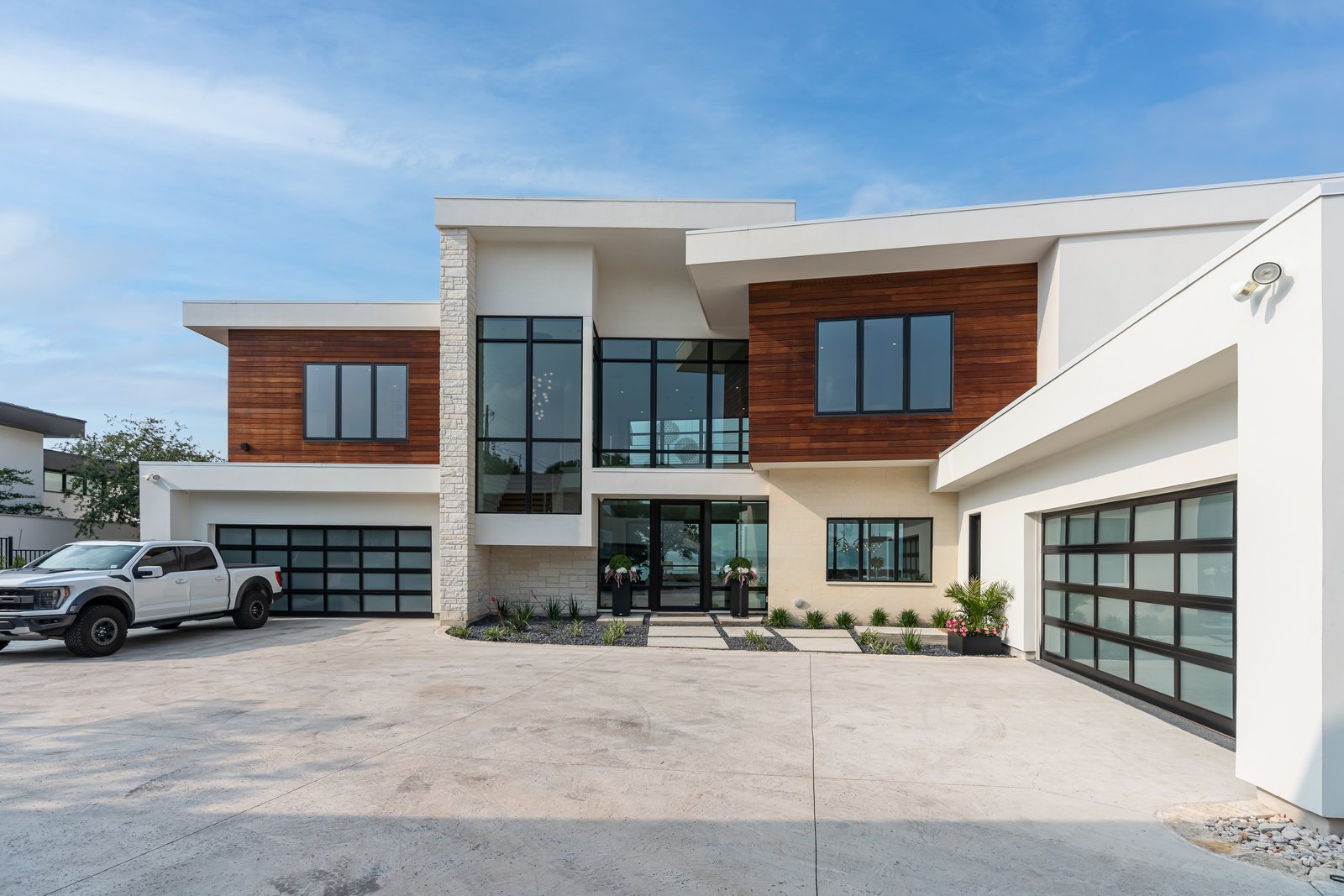 street front, white volumes with wood panels and two garages