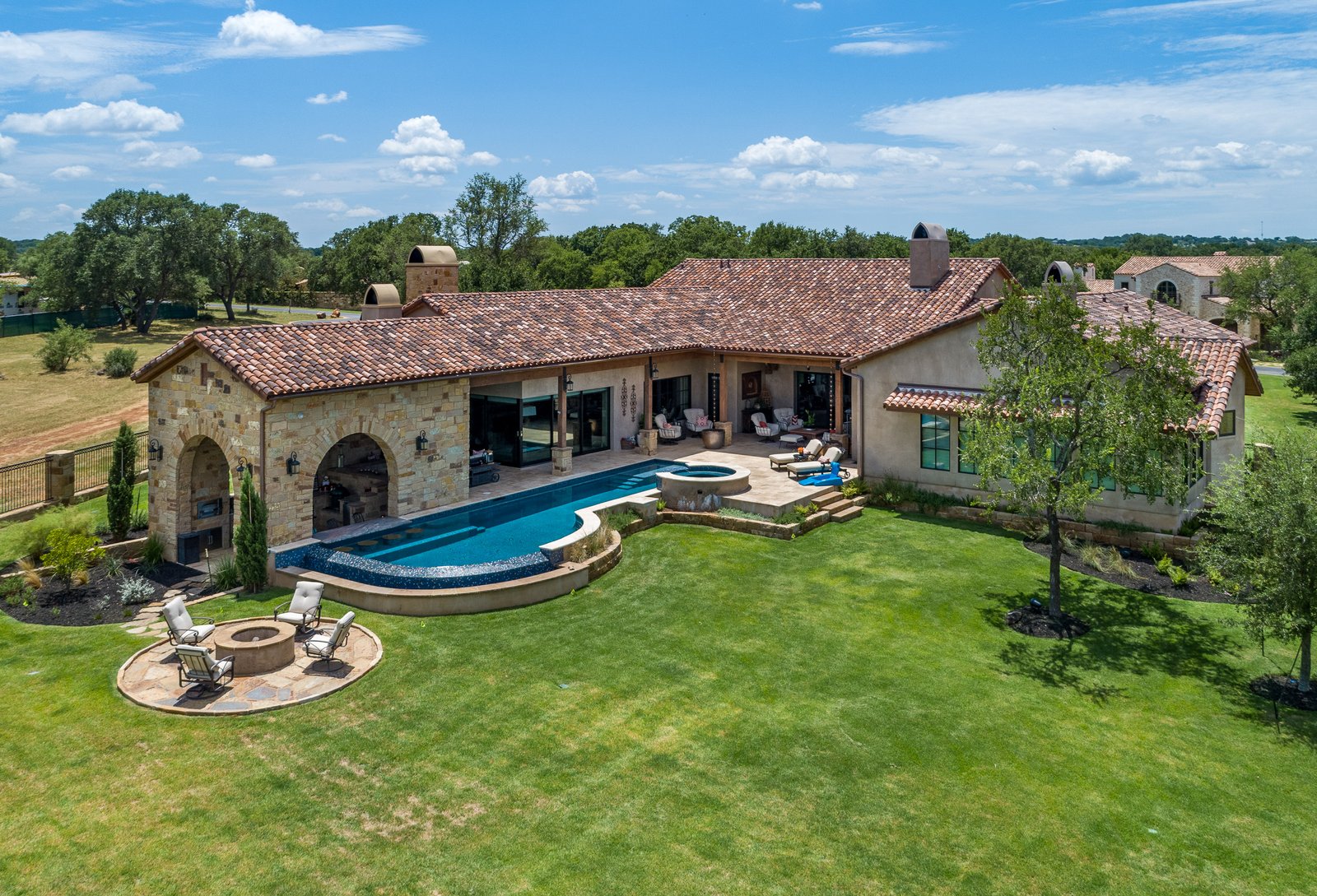 aerial of the stone house, pool and lawn