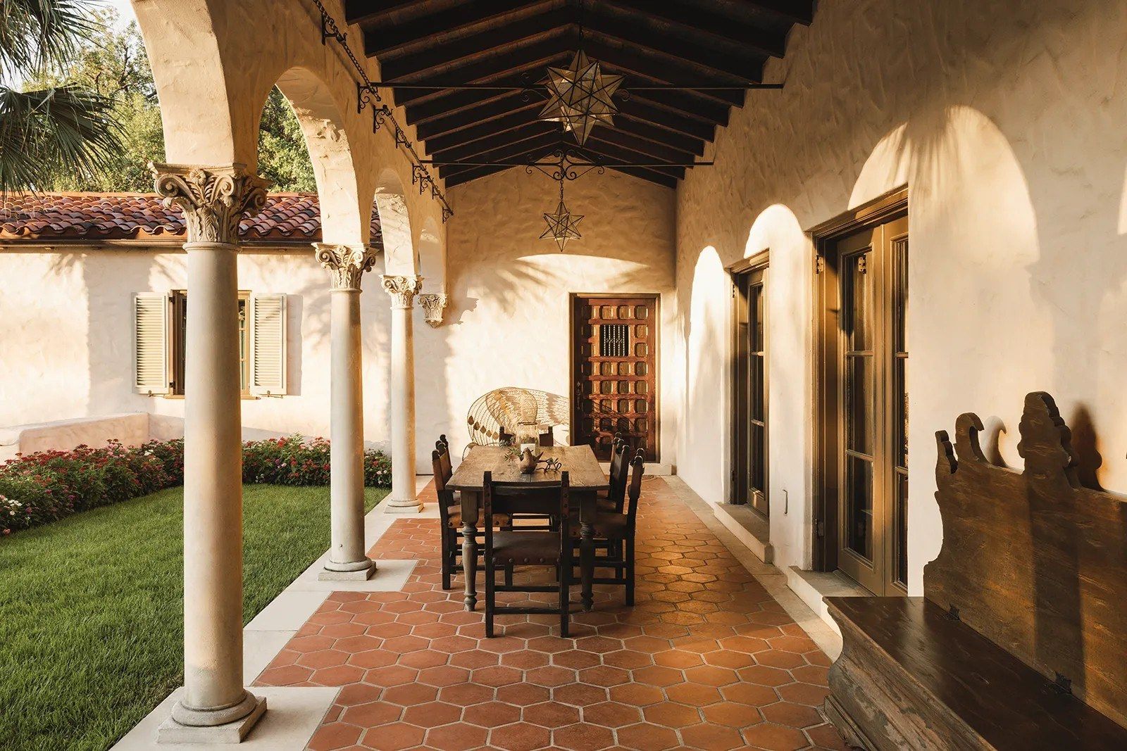 arcaded loggia with a dining table on terracotta tile